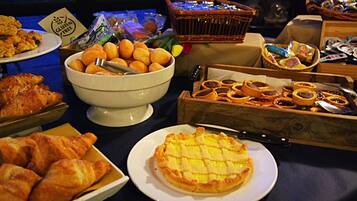 Un buffet proposant une variété de plats, notamment des croissants, une tarte et un assortiment de viennoiseries.
