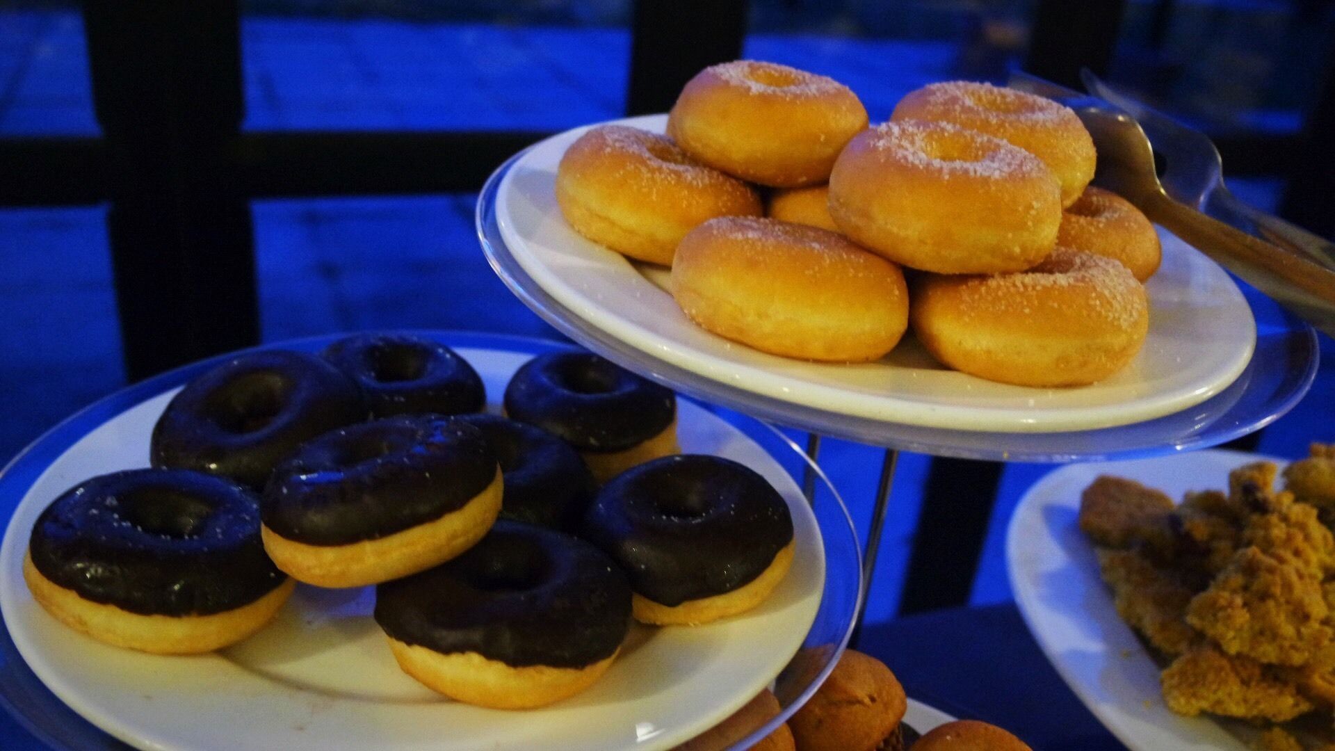 Un tavolo con piattini di ciambelle e fritture.