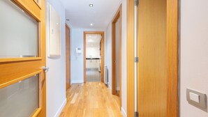 Un pasillo con puertas de madera y vista a una zona de cocina.