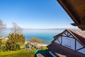 Ein traditionelles Chalet mit Seeblick und Blick auf ferne Berge.