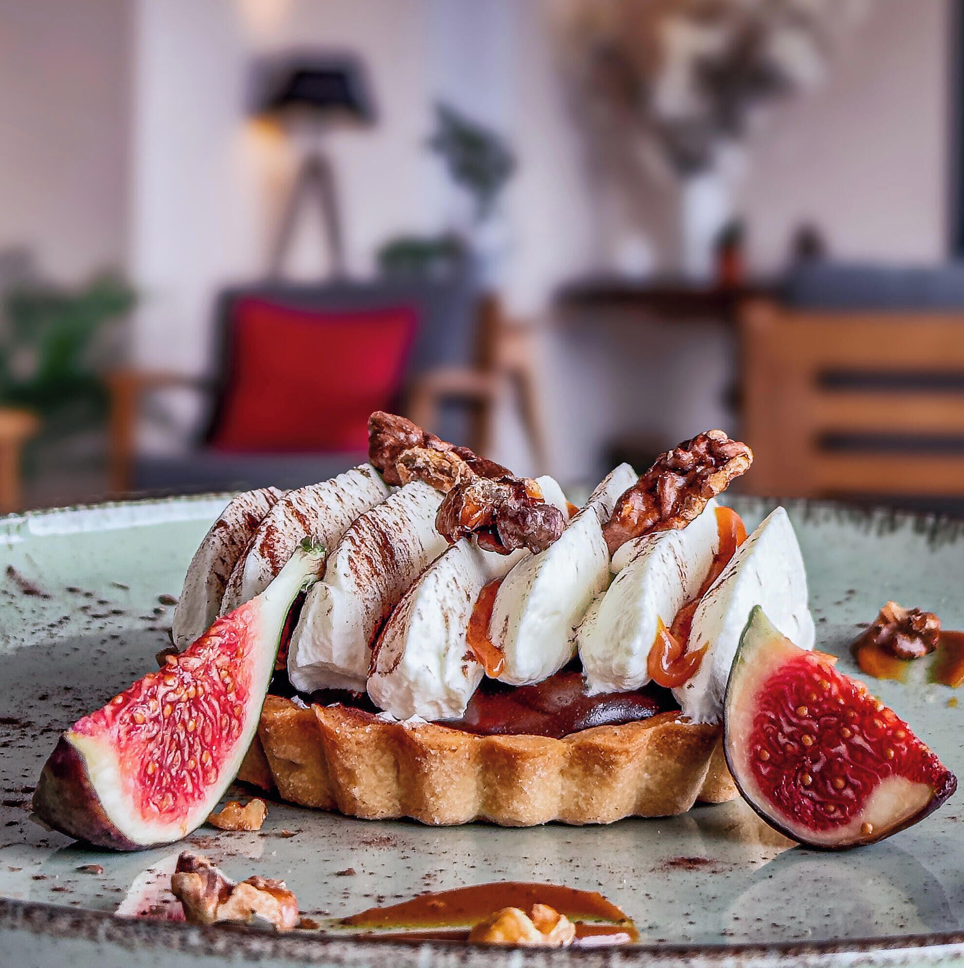 Ein Dessert mit Feigen und Nüssen auf einem Teller.
