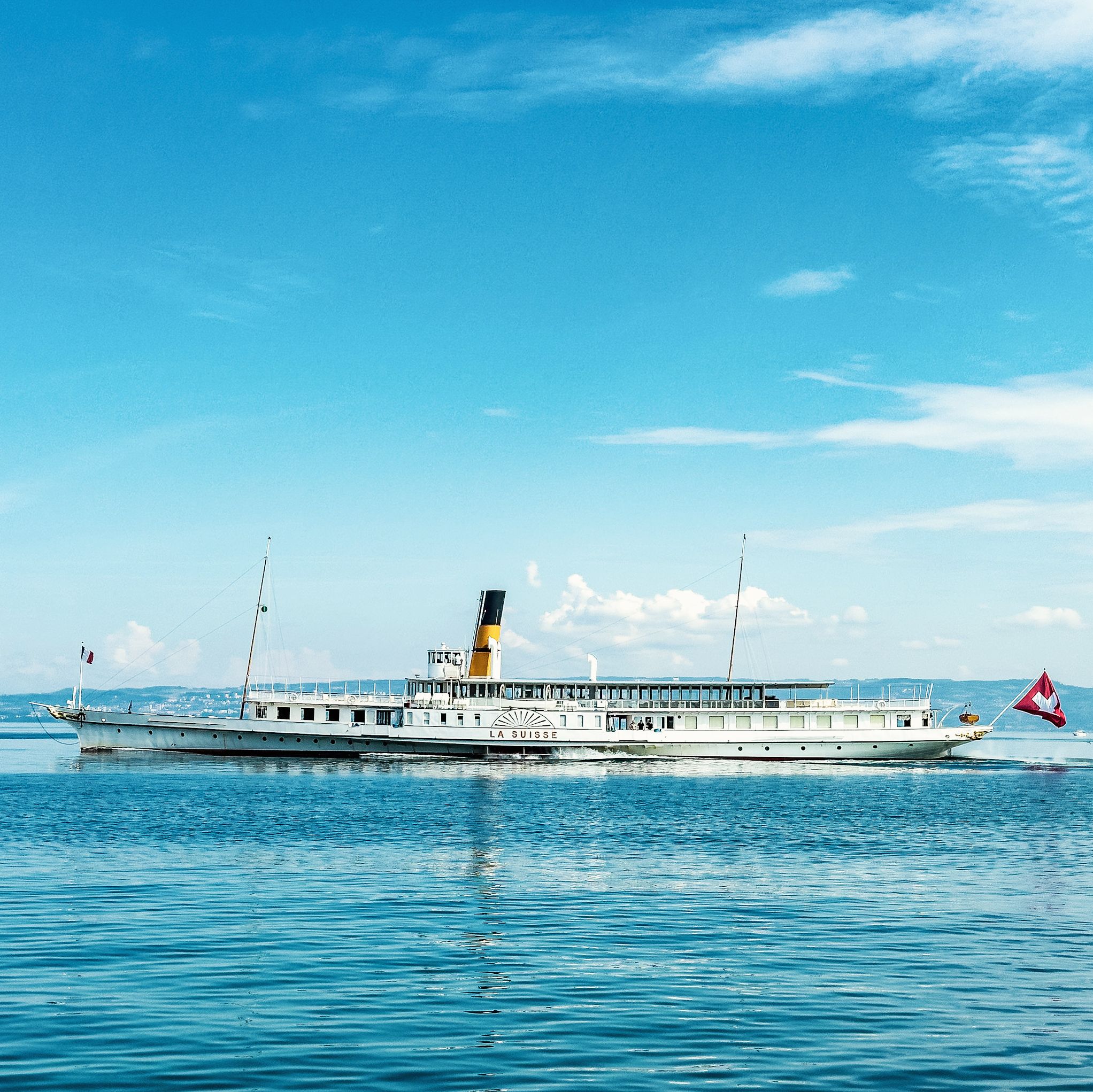 A boat named "LA SUISSE" on water.