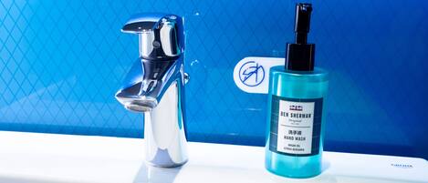 A bathroom sink with a chrome faucet and a bottle of Ben Sherman Original hand wash.