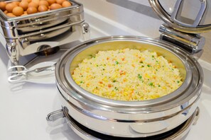 Un buffet avec un plat de riz frit et un plateau d’œufs.