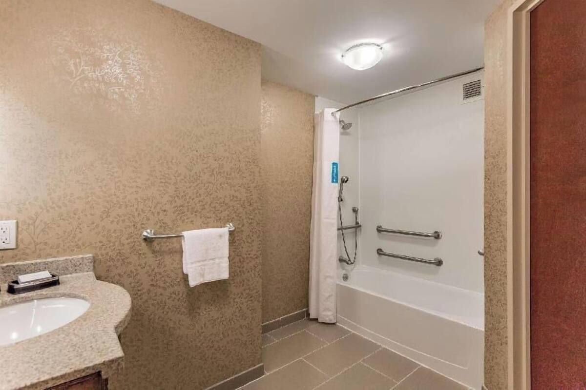 A bathroom with a sink, towel rack, shower, and bathtub.