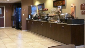 Una barra de desayuno con diferentes alimentos y una máquina de café.