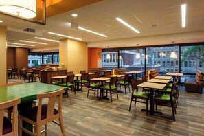 A restaurant with multiple tables and chairs, large windows, and a view of buildings outside. - Fairfield Inn & Suites Chicago Downtown/River North (Chicago)