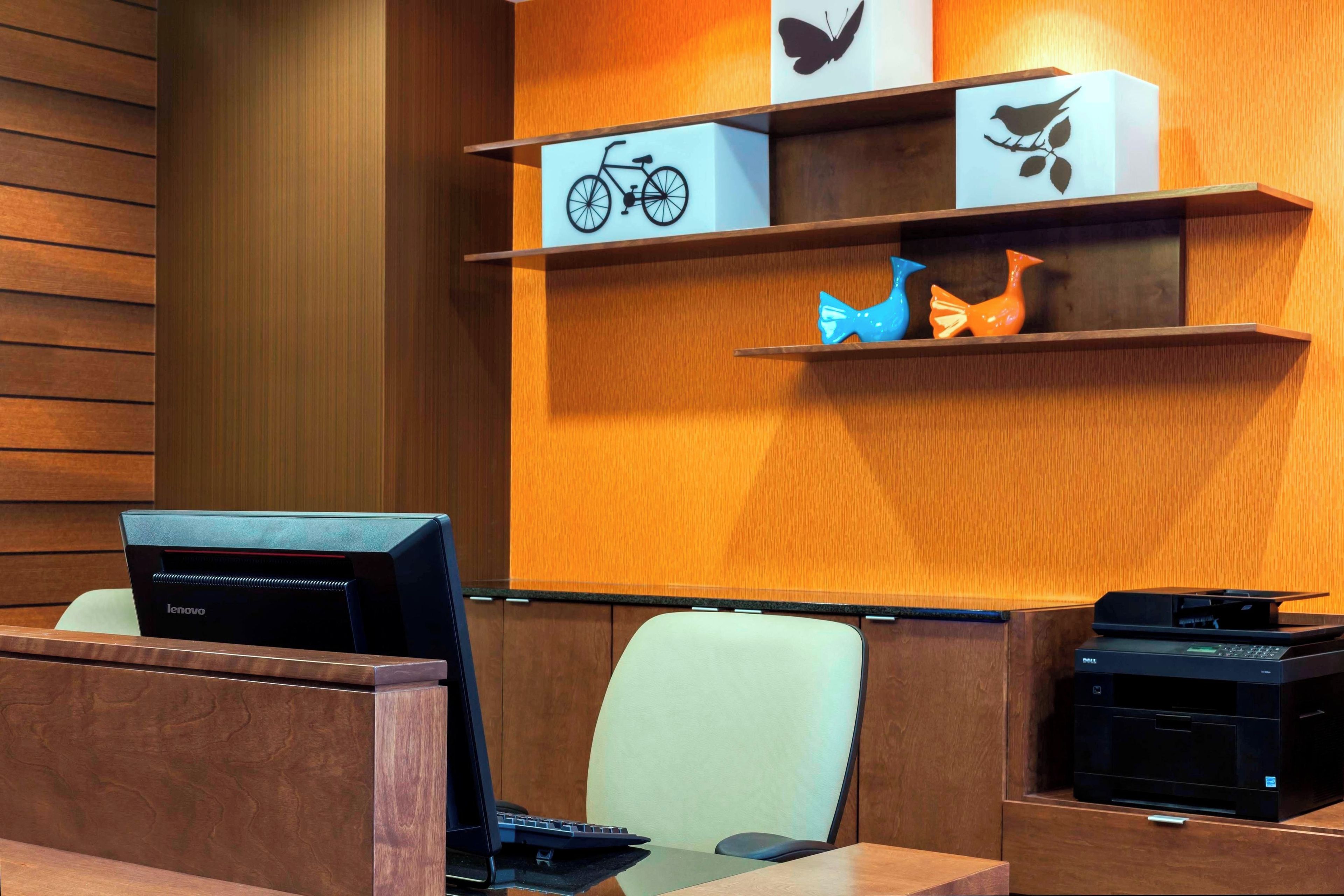 A modern office space with a desk, chairs, and a printer.