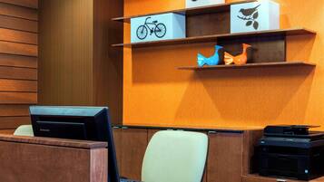 A modern office space with a desk, chairs, and a printer.