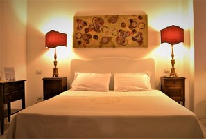 Una cama impecable con sábanas blancas y dos mesitas de noche con lámparas.