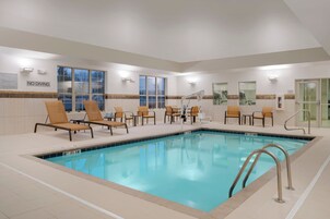 An indoor swimming pool with lounge chairs and a 'NO DIVING' sign.