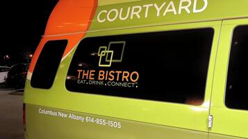 A Courtyard hotel van with "The Bistro" branding and contact information.