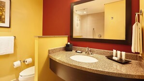 A bathroom with a white sink, a large mirror, and a towel rack. - Courtyard by Marriott Leon at the Poliforum (León)