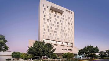 A Courtyard by Marriott hotel with a modern design, featuring a prominent entrance and a large parking area.