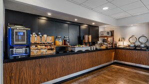 A modern kitchen with a coffee machine, jars of condiments, and a microwave. - City Express by Marriott Querétaro Juríca (Querétaro)