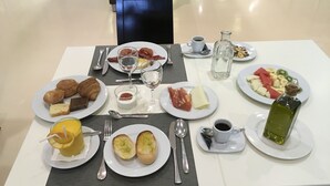 Een ontbijttafel met borden eten, drinken en toevoegingen.