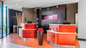 A reception area with two reception desks, a large window, and a wall-mounted sign. - Courtyard Killeen Marriott (Killeen)