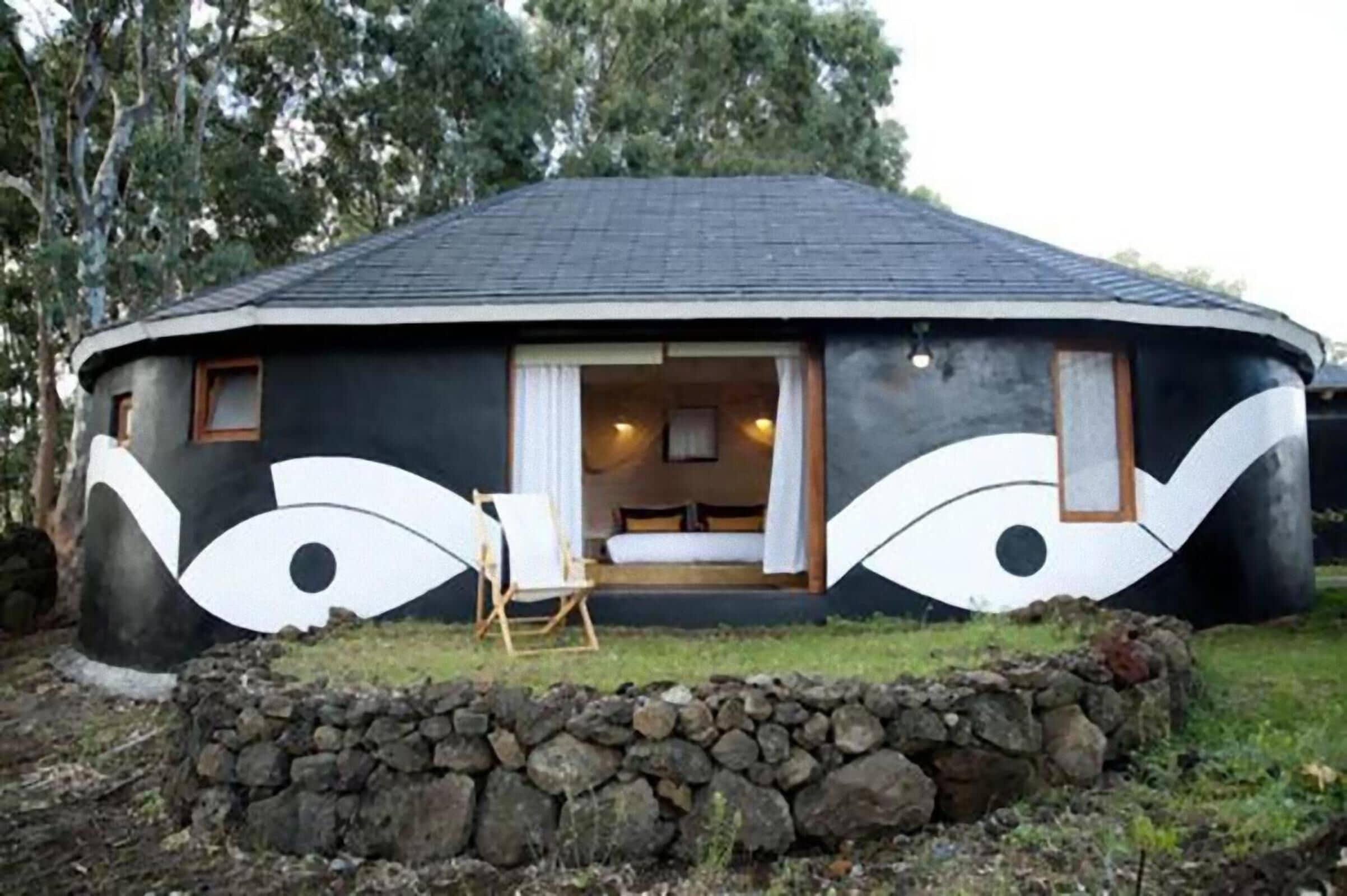 A circular building with a dark exterior and a single visible window.