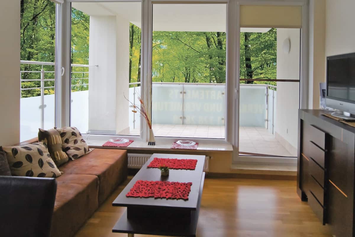 A modern living room with a sofa, a coffee table, and a TV.
