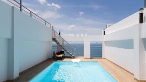 A swimming pool with a view of the sea, a staircase, and a person sitting by the pool. - Majestic Nha Trang Hotel (Nha Trang)