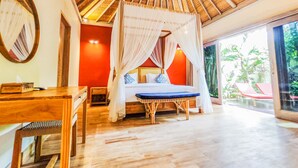 Un dormitorio con cama con dosel, una mesa de madera y vistas al exterior.