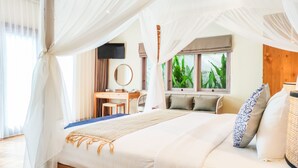 Un dormitorio con cama a dosel, un escritorio y una ventana con plantas.