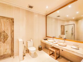 Une salle de bain moderne avec une porte en bois, des toilettes, un lavabo avec un miroir et un espace douche.