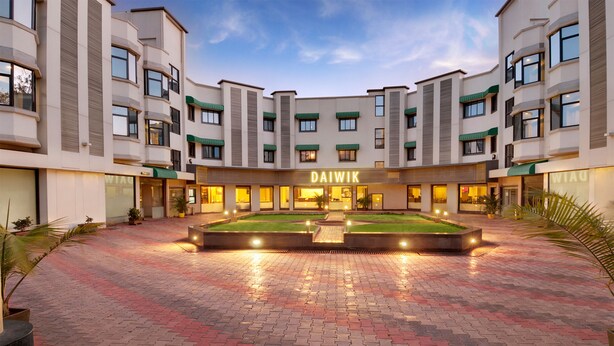 Ein modernes Hotel mit Innenhof, mehreren Etagen und einem gut beleuchteten Eingang.