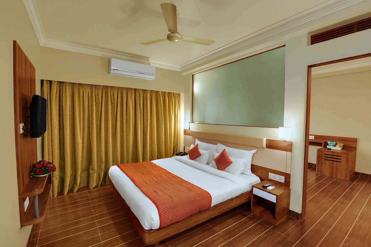 A hotel room with a bed, wooden headboard, bedside table, and a ceiling fan.