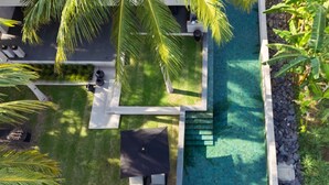 A rooftop pool area with palm trees and a small seating area. - The Lombok Lodge Suites & Private Villas (Tanjung)