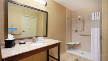 Un baño con lavamanos, espejo y ducha.