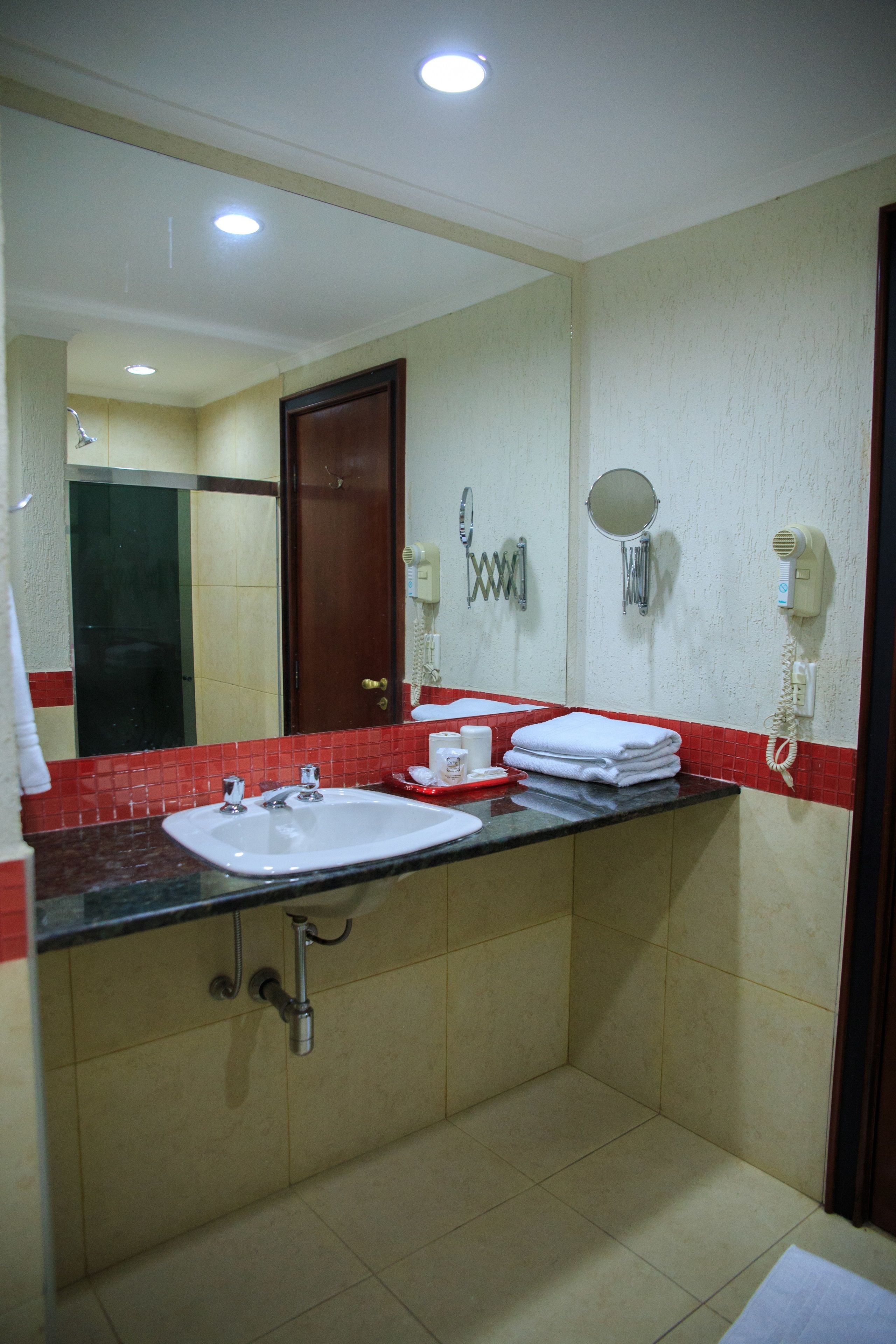 A bathroom with a sink, mirror, and towel rack.