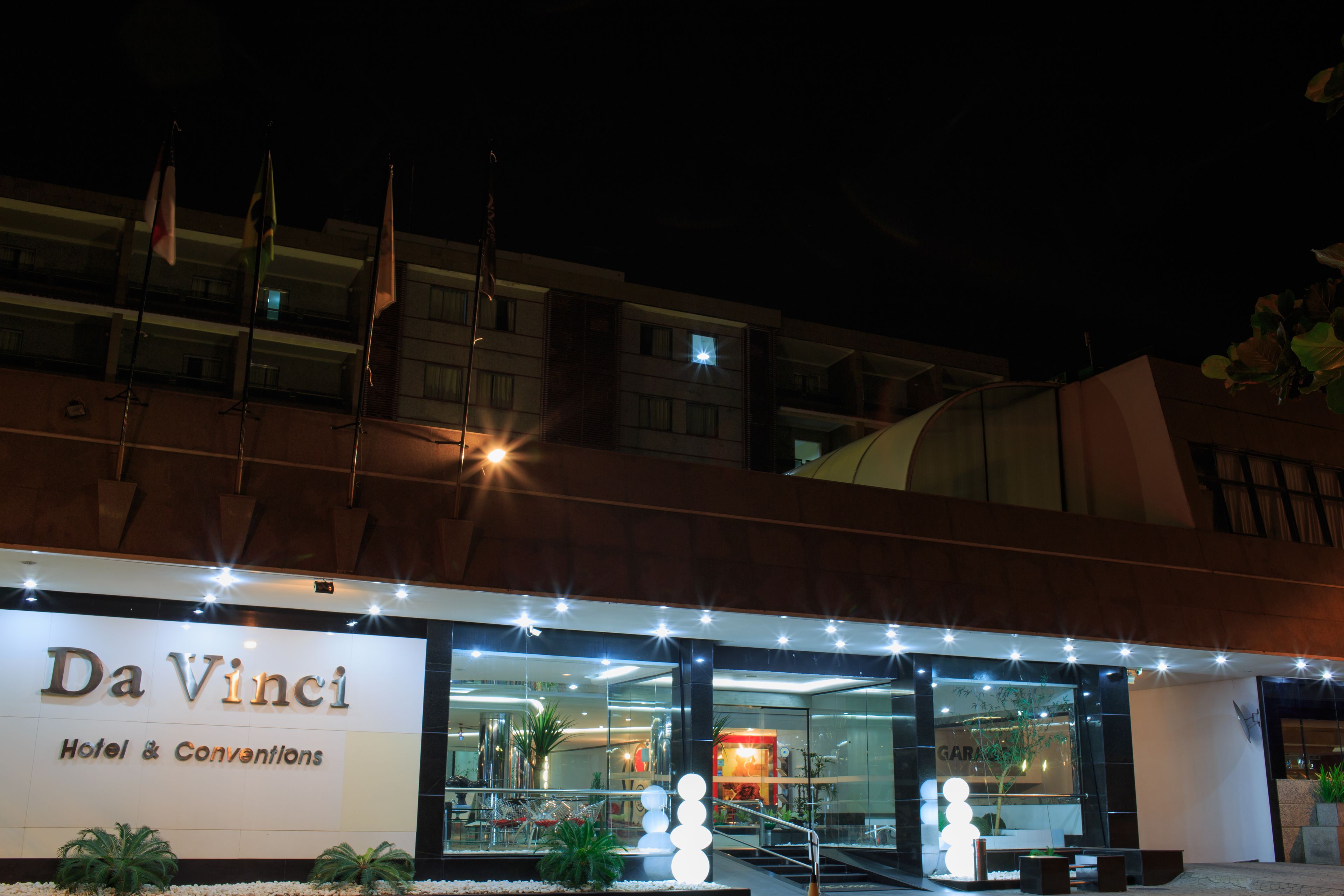 The exterior of Da Vinci Hotel & Conventions with a modern design, featuring a prominent sign, a glass entrance, and a well-lit facade.