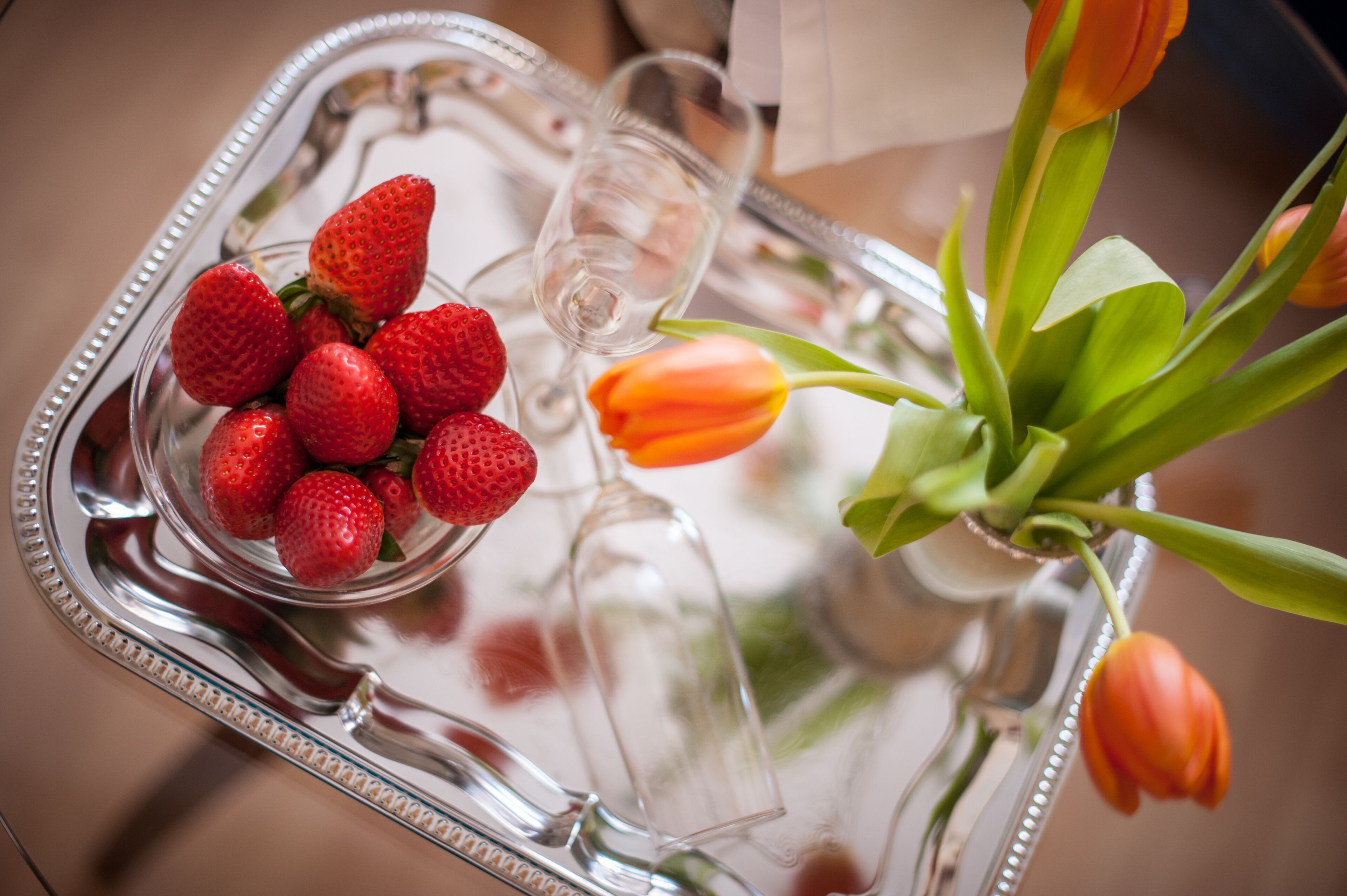 Una bandeja con fresas y tulipanes.