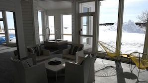 A spacious room with large windows, a seating area with white furniture, and a view of a snowy landscape. - Pite Havsbad (Pitea)