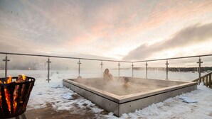 A hot tub in a snowy outdoor setting with a view of a lake and mountains in the background. - Pite Havsbad (Pitea)