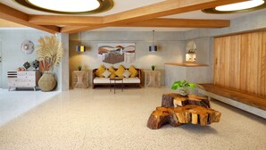A modern living room with a wooden ceiling, a sofa with yellow cushions, a round coffee table, and a large abstract painting on the wall. - Episode Kuta Bali (Kuta)