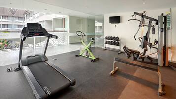 A modern gym with a treadmill, stationary bike, and weightlifting equipment.
