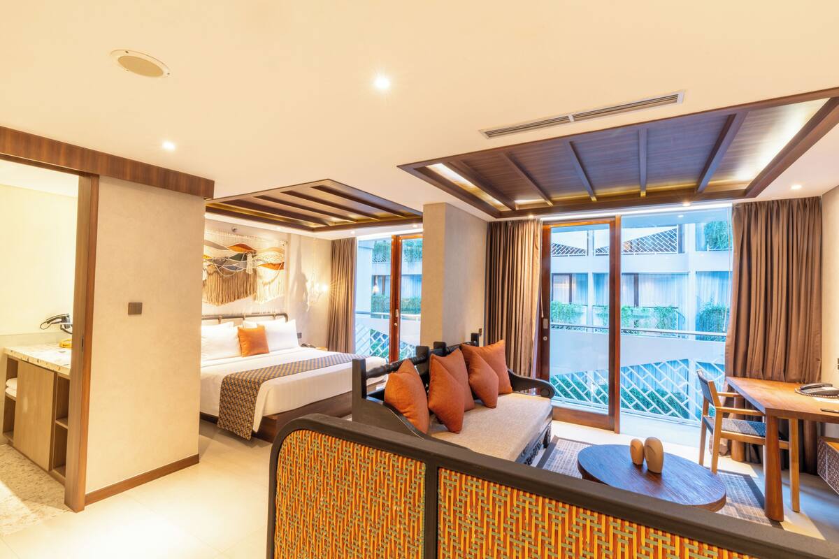 Une chambre d’hôtel comprenant un lit, un canapé, un coin repas et un balcon avec vue.