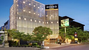 A modern hotel with a large digital billboard, a well-maintained garden area, and a prominent entrance. - Episode Kuta Bali (Kuta)