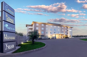 Un hotel con un letrero que enumera servicios como restaurante, spa, tienda de recuerdos y salón de belleza.