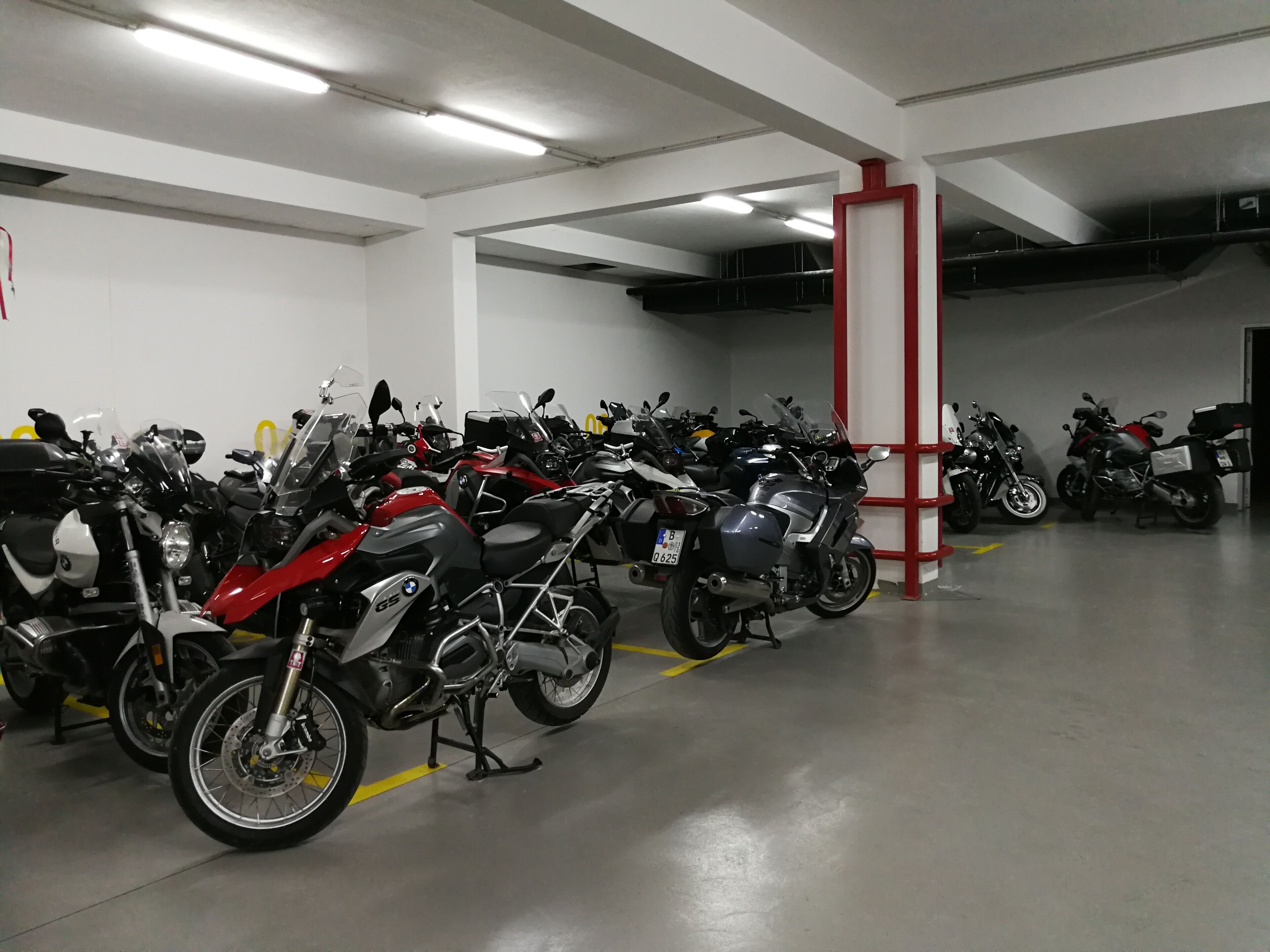 Un estacionamiento con varias motocicletas aparcadas en filas.
