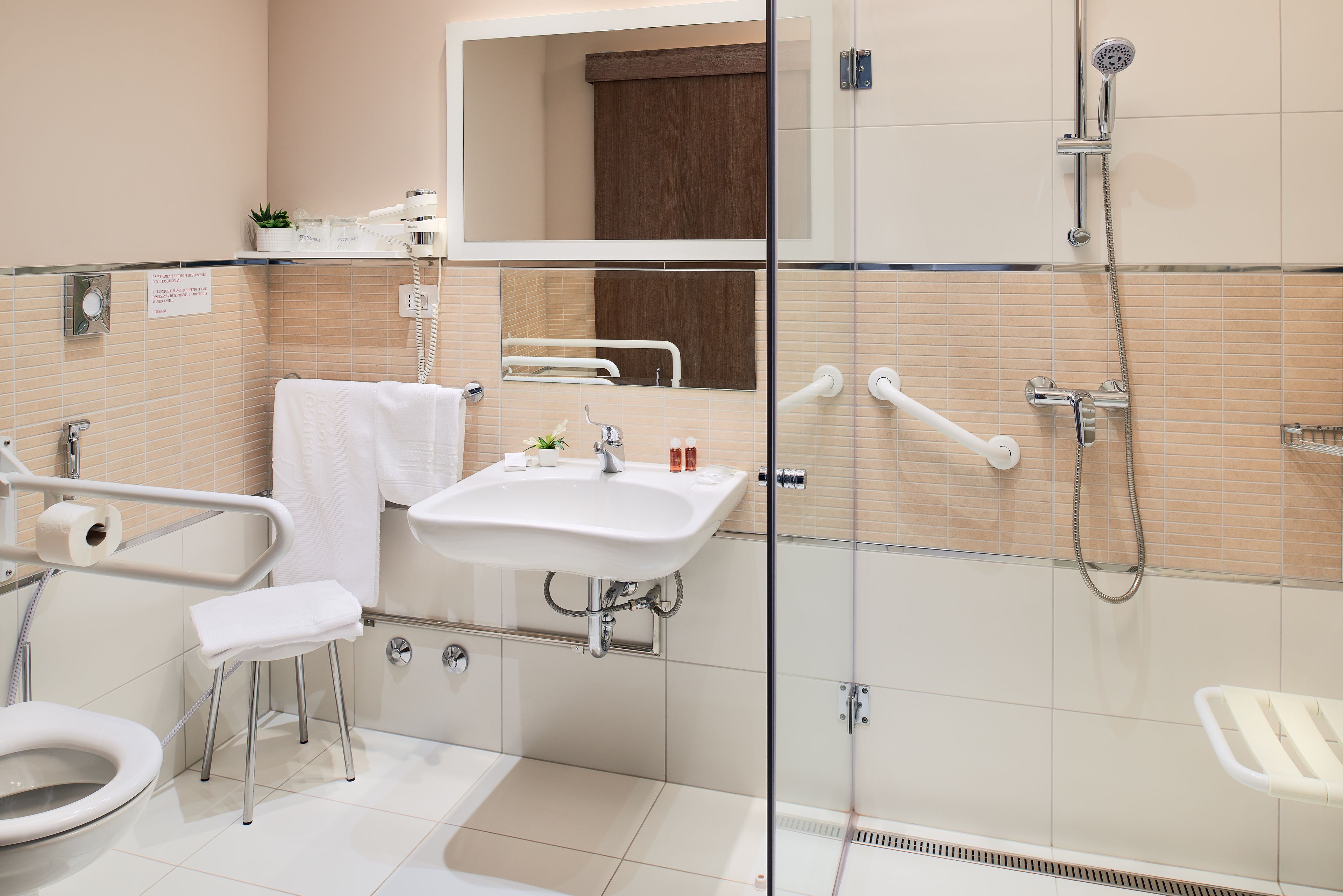 Une salle de bain moderne avec une douche à parois de verre, un lavabo blanc et des toilettes.
