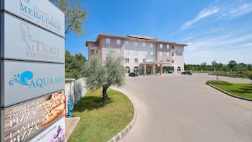 A hotel with a signboard advertising a restaurant, spa, and wellness center.