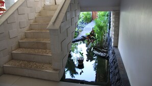 A staircase leading to a small indoor garden with a water feature. - Jimbaran Cliffs Private Pool Hotel & Spa (Nusa Dua)