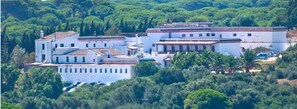 A white building with multiple sections, surrounded by greenery. - El Palomar de la Breña (Barbate)