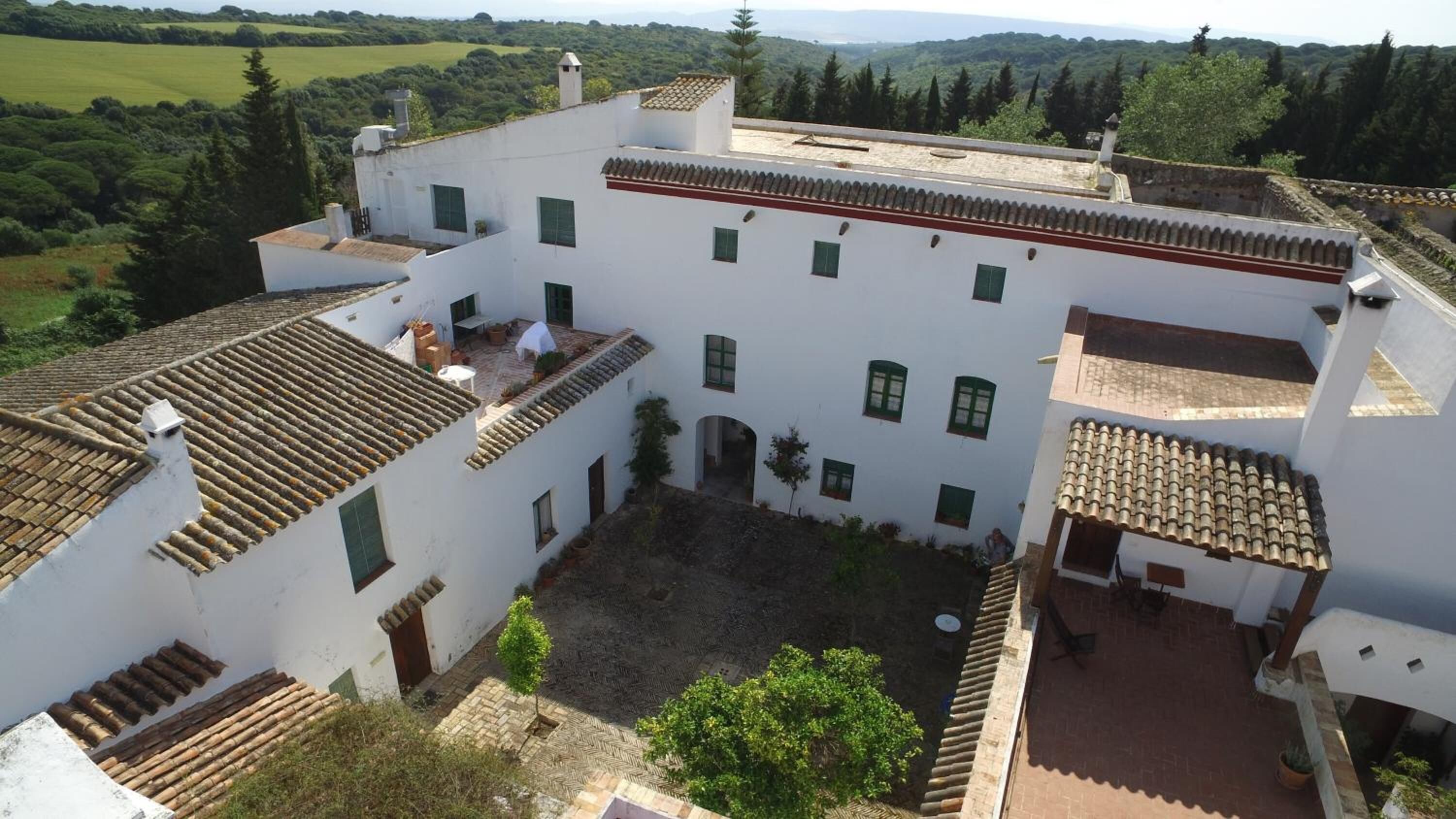A white building with multiple windows and a courtyard.