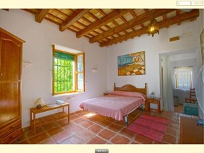 Traditional room with a single bed, bedside table, and large window.