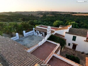Experience the serene charm of this traditional Mediterranean-style building, surrounded by lush greenery and rolling hills.