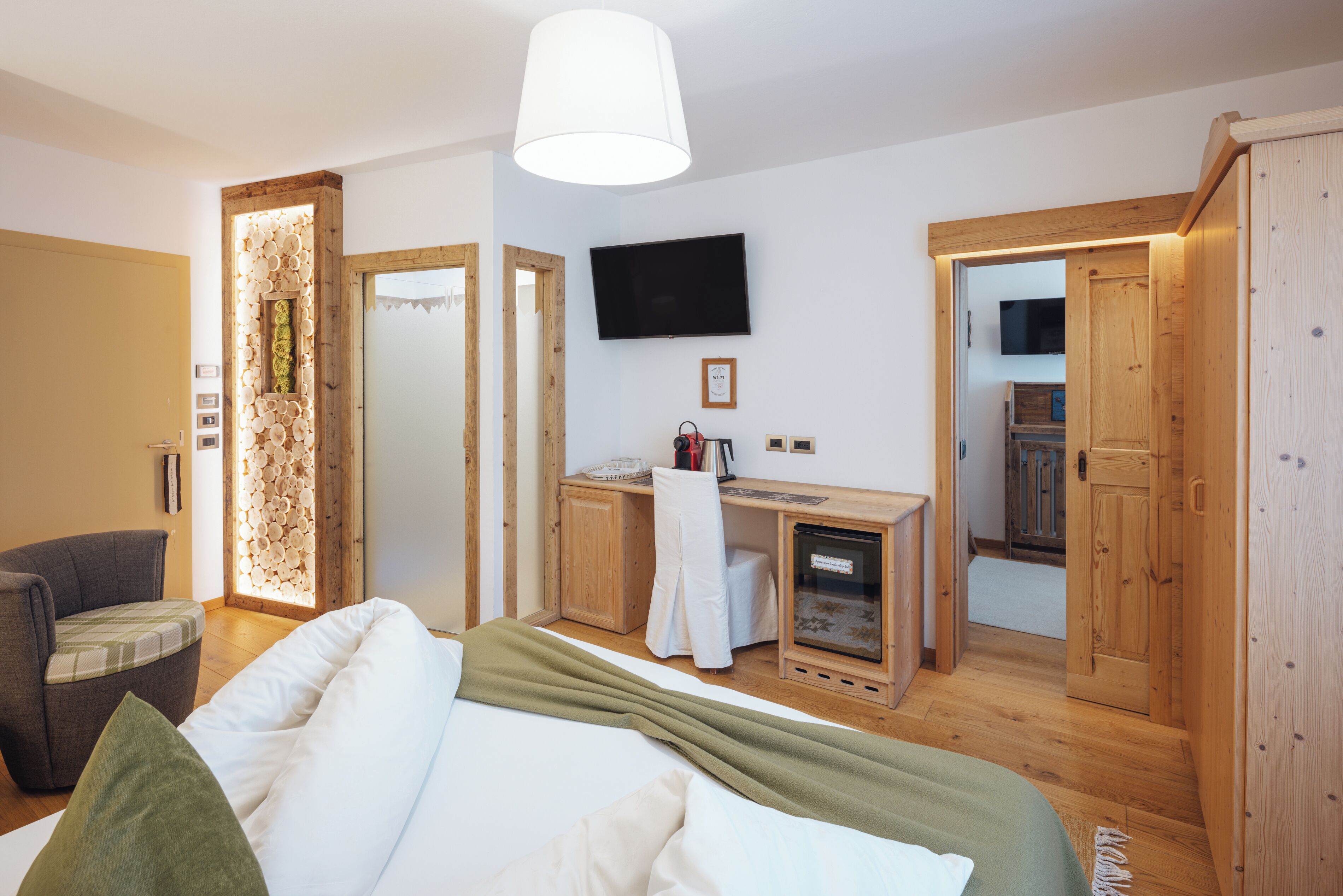 Un dormitorio con cama, escritorio, silla y televisor.